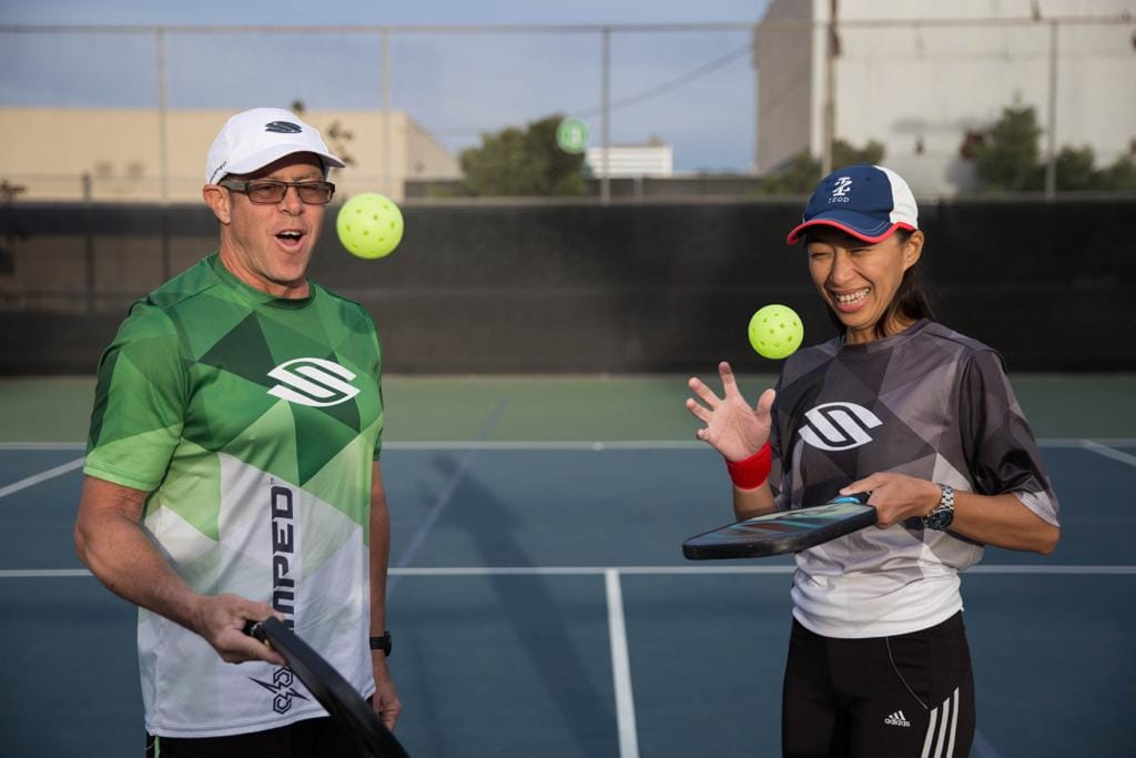 Coach Matty and Coach MeiShen Klein holding pickleball paddles